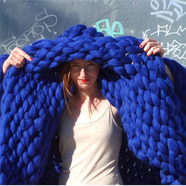 "Handmade chunky knit blanket, super soft texture, vibrant colors draped on furniture, decorative and cozy home accent."
