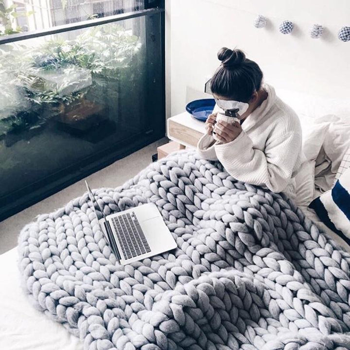 "Handmade chunky knit blanket, super soft texture, vibrant colors draped on furniture, decorative and cozy home accent."