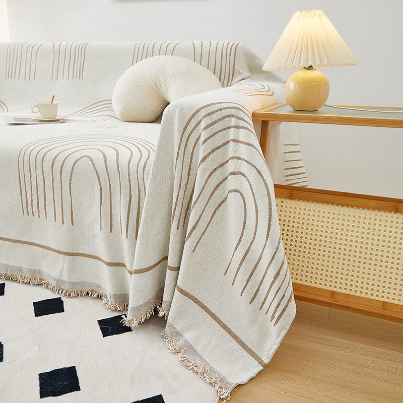 Luxurious sofa throw cover for sectionals, elegantly draped in soft, stretchable fabric, ideal for modern home decor.
