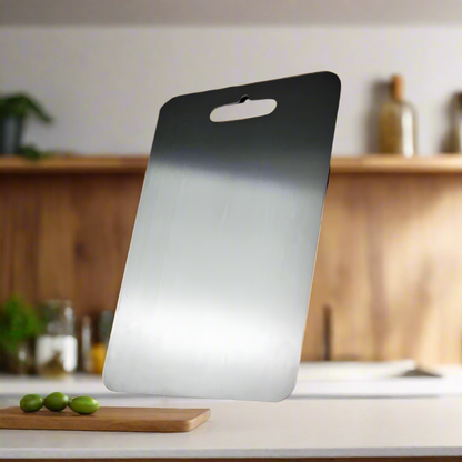 Medical grade titanium cutting board with non-porous silver surface, rounded edges, and ergonomic design for ultimate hygiene
