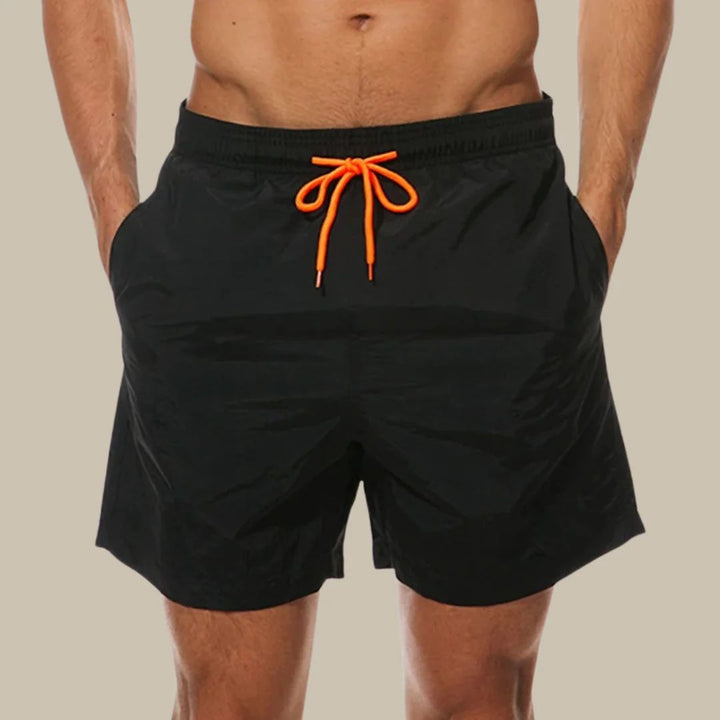 Men's blue drawstring swim shorts with pockets, ideal for summer beachwear & casual outings. Quick-dry fabric.