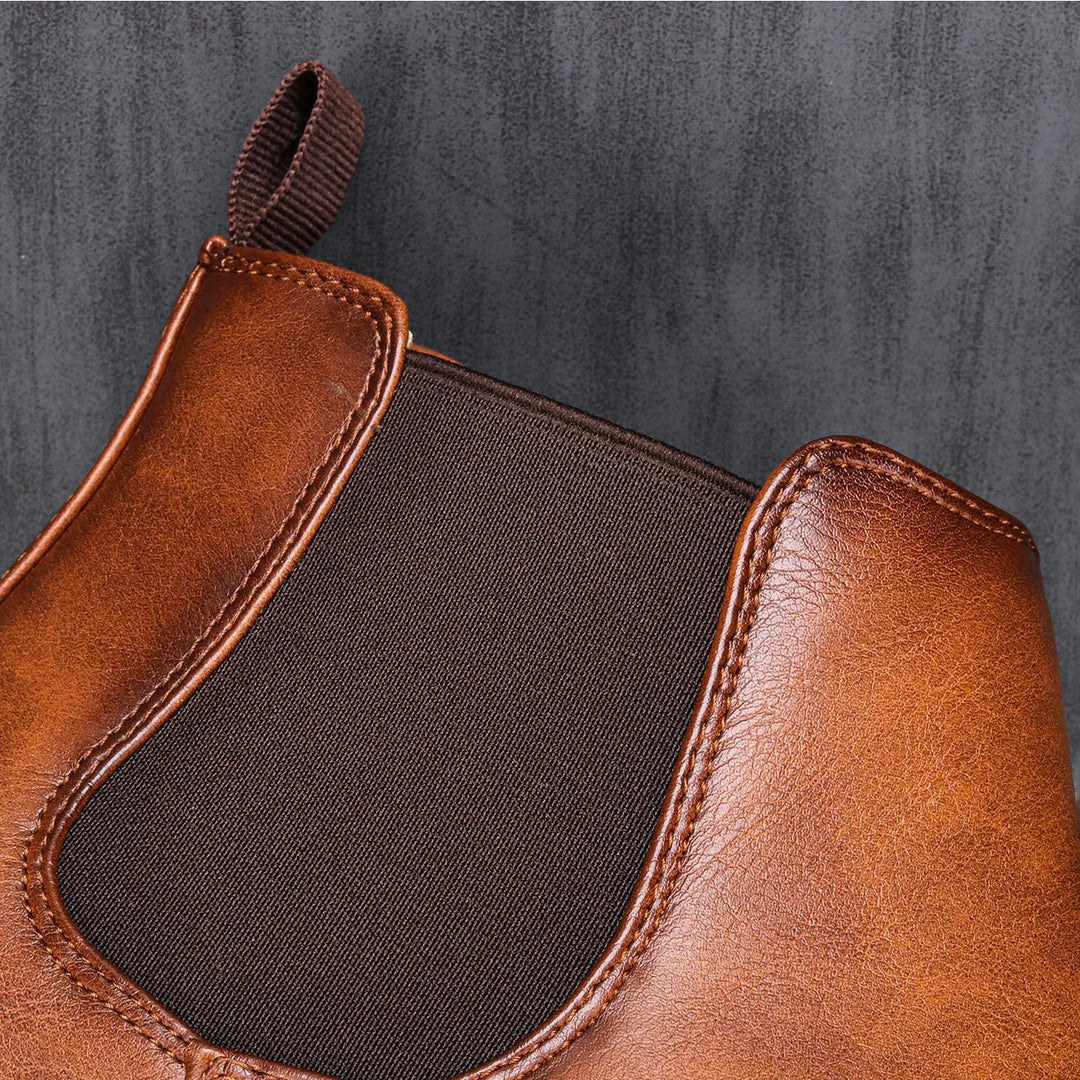 Close-up of rich brown leather men's Chelsea boots, highlighting quality material and comfortable fit.