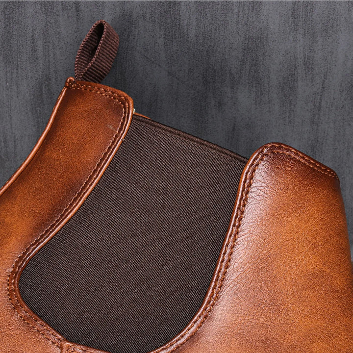 Close-up of rich brown leather men's Chelsea boots, highlighting quality material and comfortable fit.