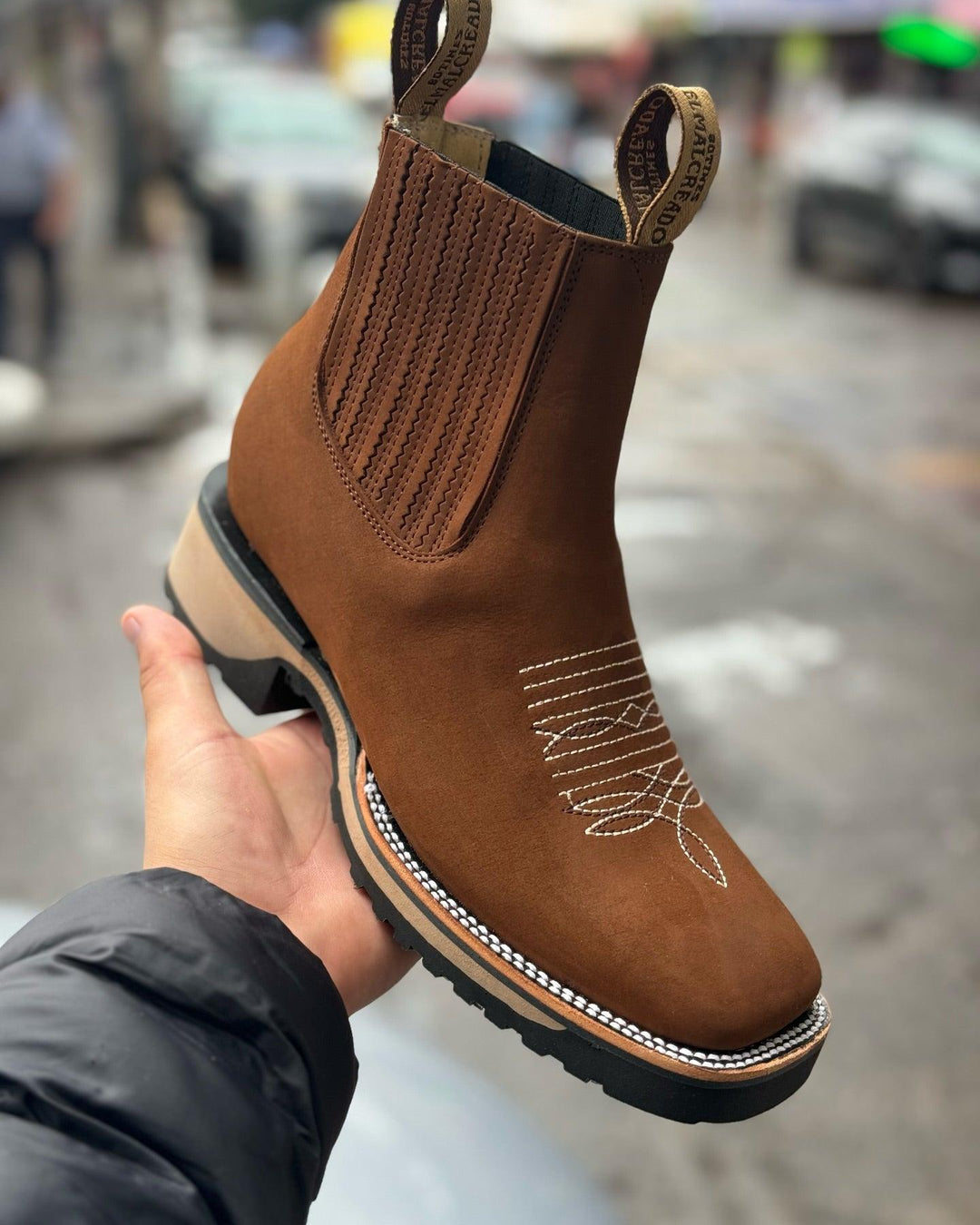 Close-up of men's embroidered Western ankle cowboy boots, showcasing rugged texture and detailed stitching for casual wear.