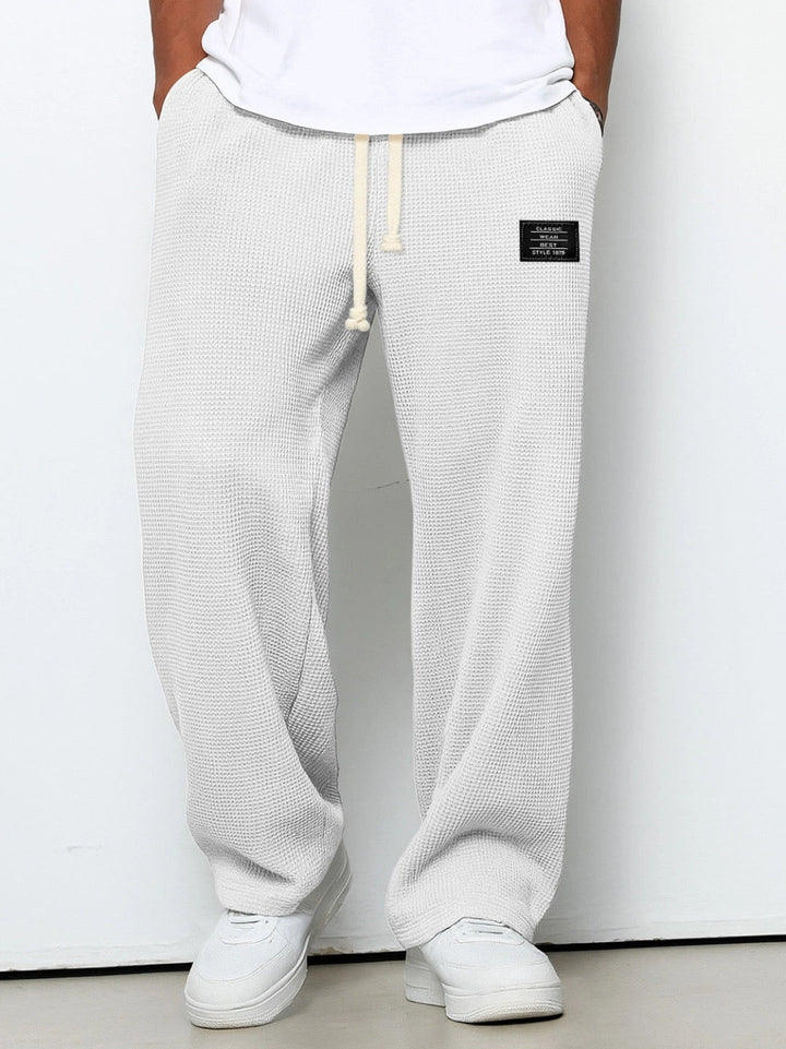 Men's loose fit jogging pants with practical side pockets, great for athletic and home wear.