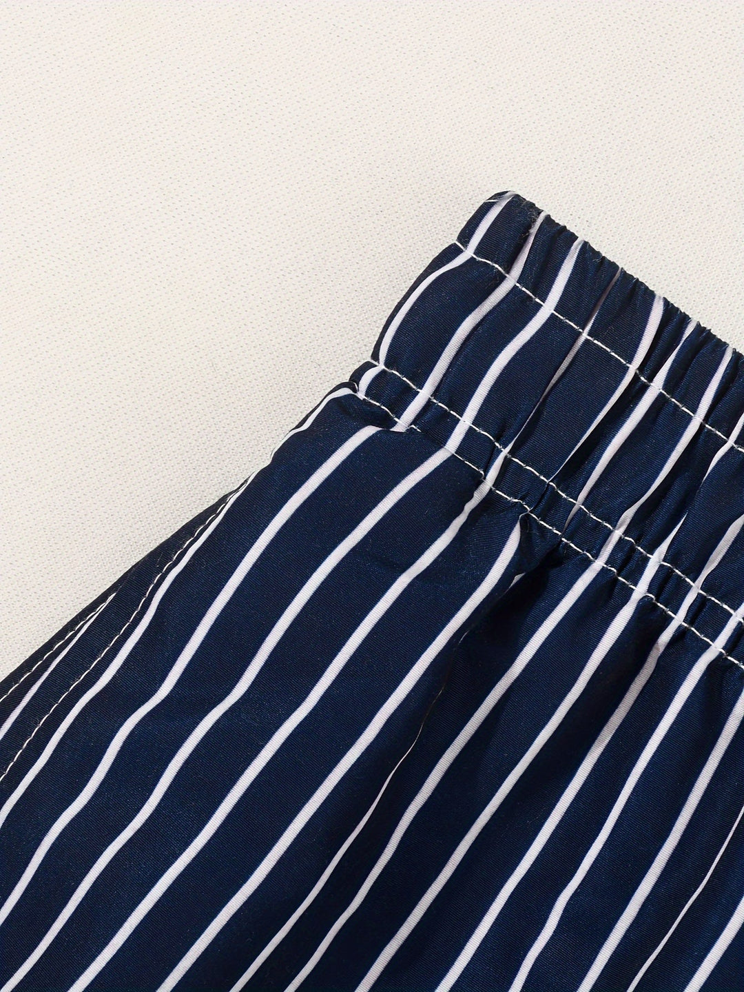 Navy & white striped men's swim shorts with comfortable adjustable drawstring waist for the beach.