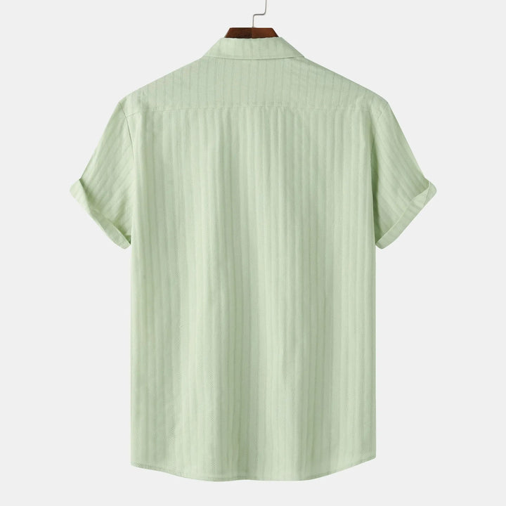 Light blue men's casual button-down shirt. Short sleeve, collared for summer fashion.