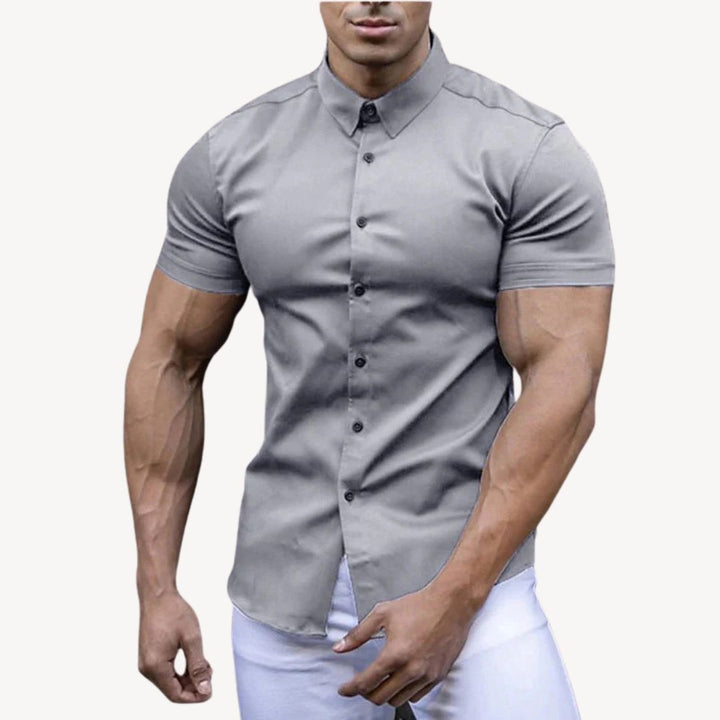 "Men's black muscle fit shirt, cotton spandex, short sleeve, highlighting athletic build, ideal for versatile styling."