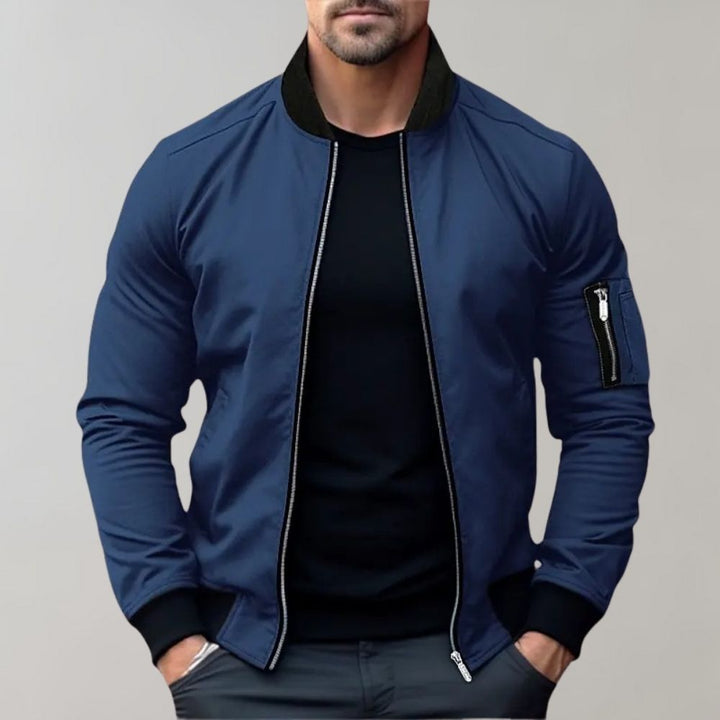 "Men's blue bomber jacket with zipper pockets, stylish fit, lightweight fabric, perfect for cool evenings."
