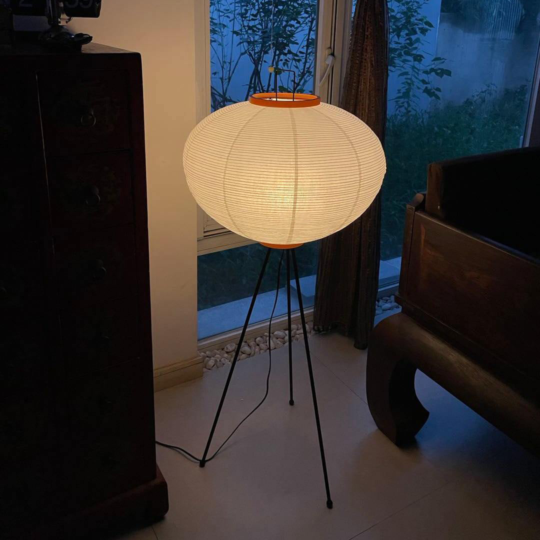 "Minimalist rice paper floor lamp with sleek metal frame and soft diffused light, perfect for creating a warm ambiance."