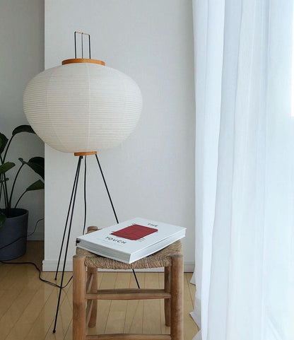 "Minimalist rice paper floor lamp with sleek metal frame and soft diffused light, perfect for creating a warm ambiance."