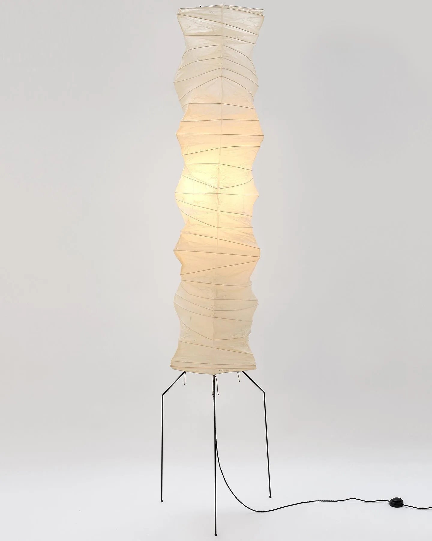 "Minimalist rice paper floor lamp with sleek metal frame and soft diffused light, perfect for creating a warm ambiance."