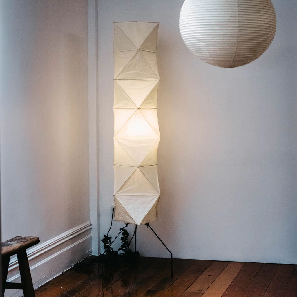 "Minimalist rice paper floor lamp with sleek metal frame and soft diffused light, perfect for creating a warm ambiance."