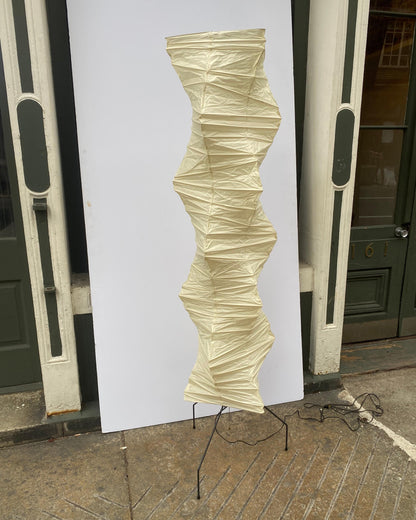 "Minimalist rice paper floor lamp with sleek metal frame and soft diffused light, perfect for creating a warm ambiance."