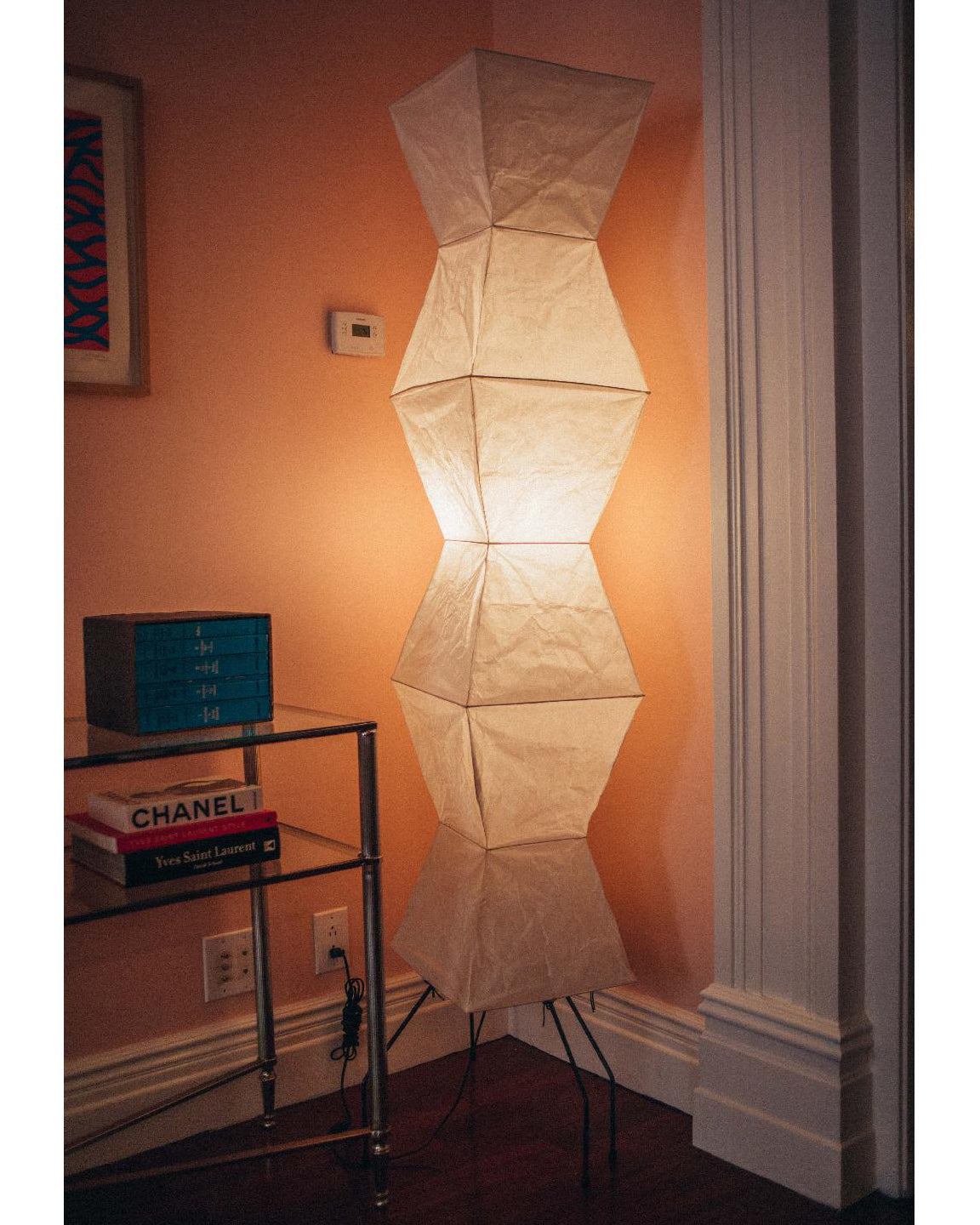 "Minimalist rice paper floor lamp with sleek metal frame and soft diffused light, perfect for creating a warm ambiance."