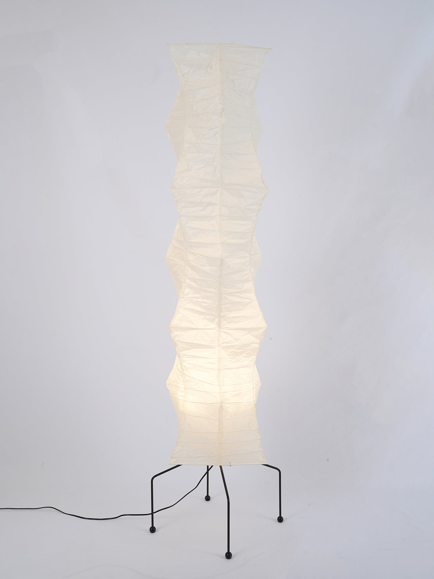 "Minimalist rice paper floor lamp with sleek metal frame and soft diffused light, perfect for creating a warm ambiance."