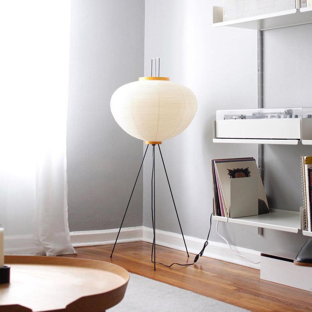 "Minimalist rice paper floor lamp with sleek metal frame and soft diffused light, perfect for creating a warm ambiance."