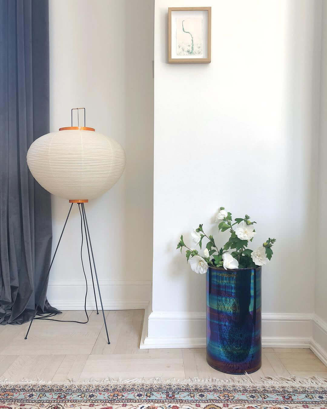 "Minimalist rice paper floor lamp with sleek metal frame and soft diffused light, perfect for creating a warm ambiance."