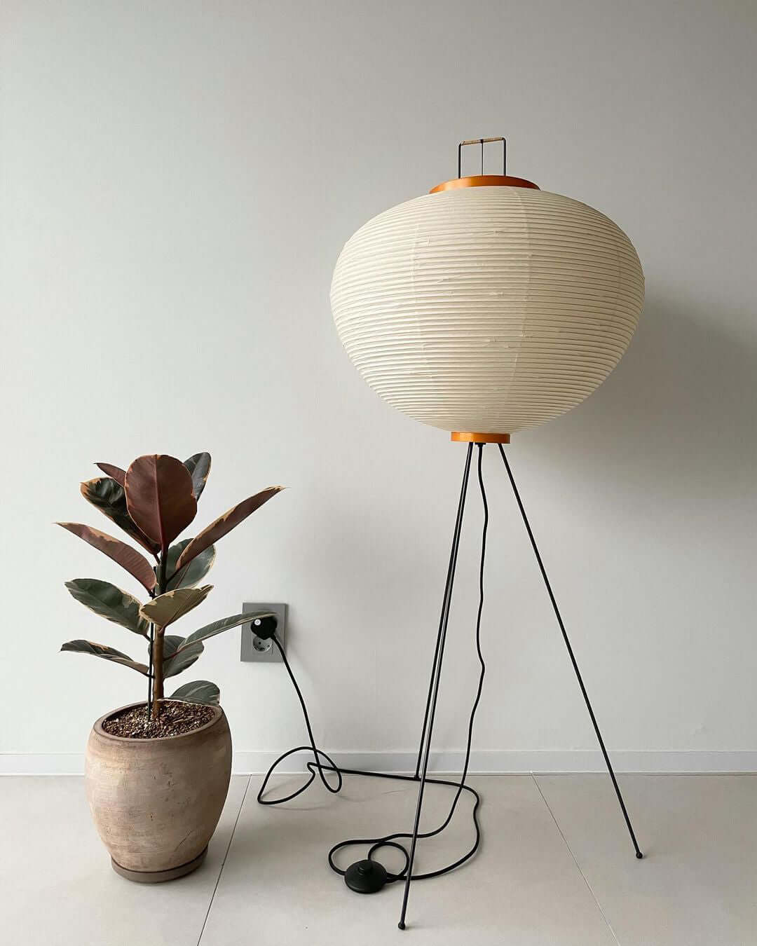 "Minimalist rice paper floor lamp with sleek metal frame and soft diffused light, perfect for creating a warm ambiance."