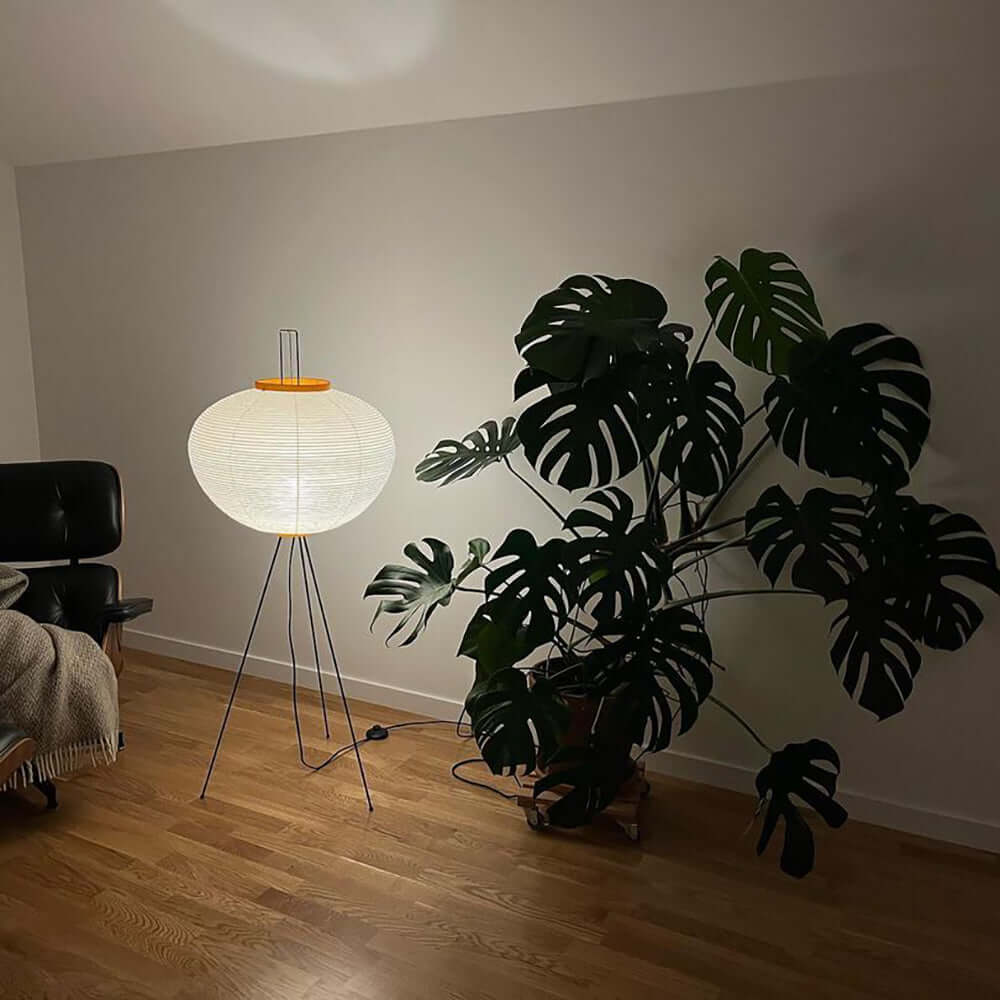 "Minimalist rice paper floor lamp with sleek metal frame and soft diffused light, perfect for creating a warm ambiance."