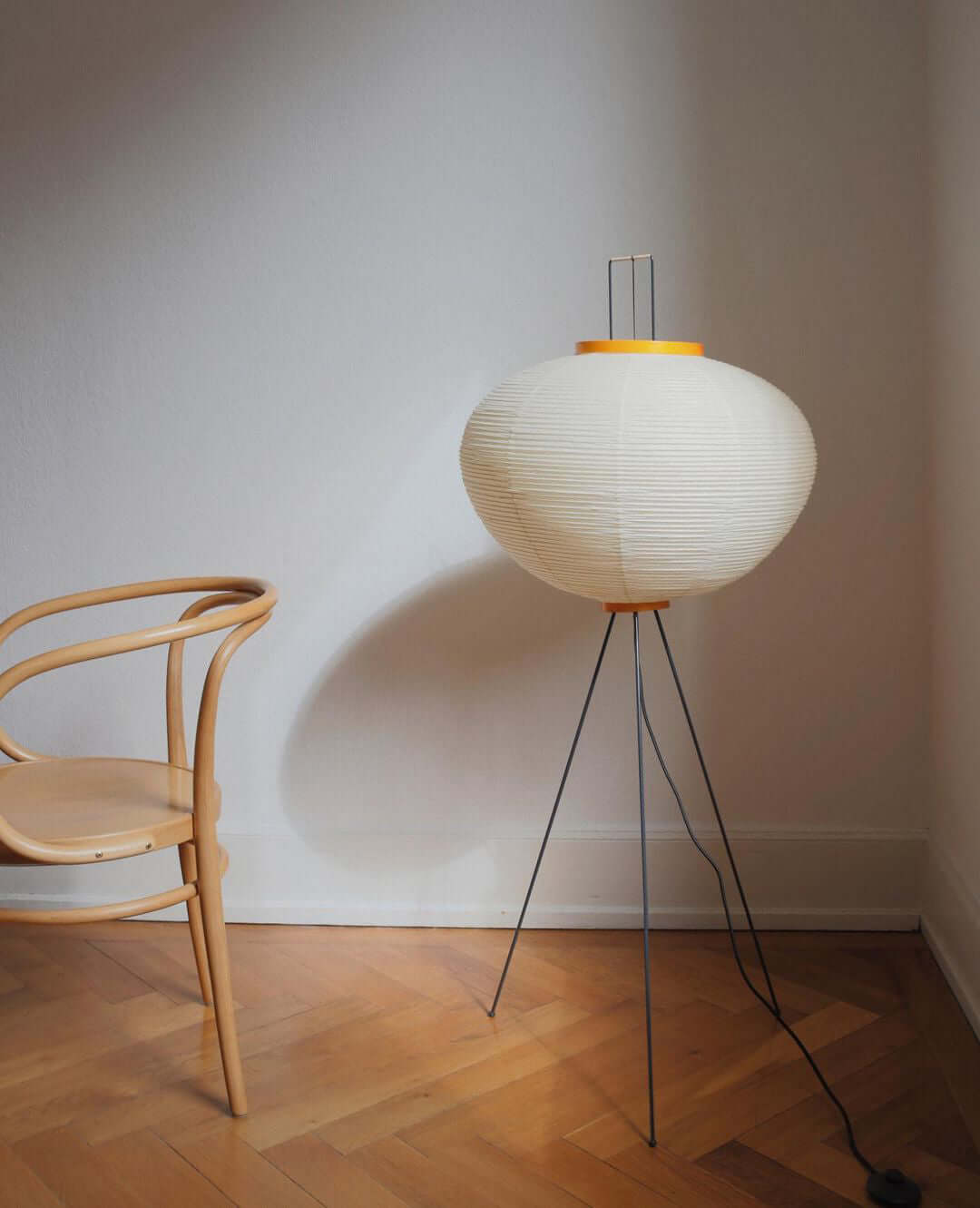"Minimalist rice paper floor lamp with sleek metal frame and soft diffused light, perfect for creating a warm ambiance."