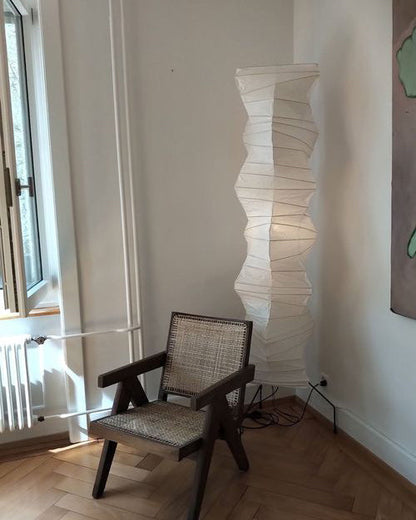 "Minimalist rice paper floor lamp with sleek metal frame and soft diffused light, perfect for creating a warm ambiance."