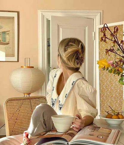 "Minimalist rice paper floor lamp with sleek metal frame and soft diffused light, perfect for creating a warm ambiance."