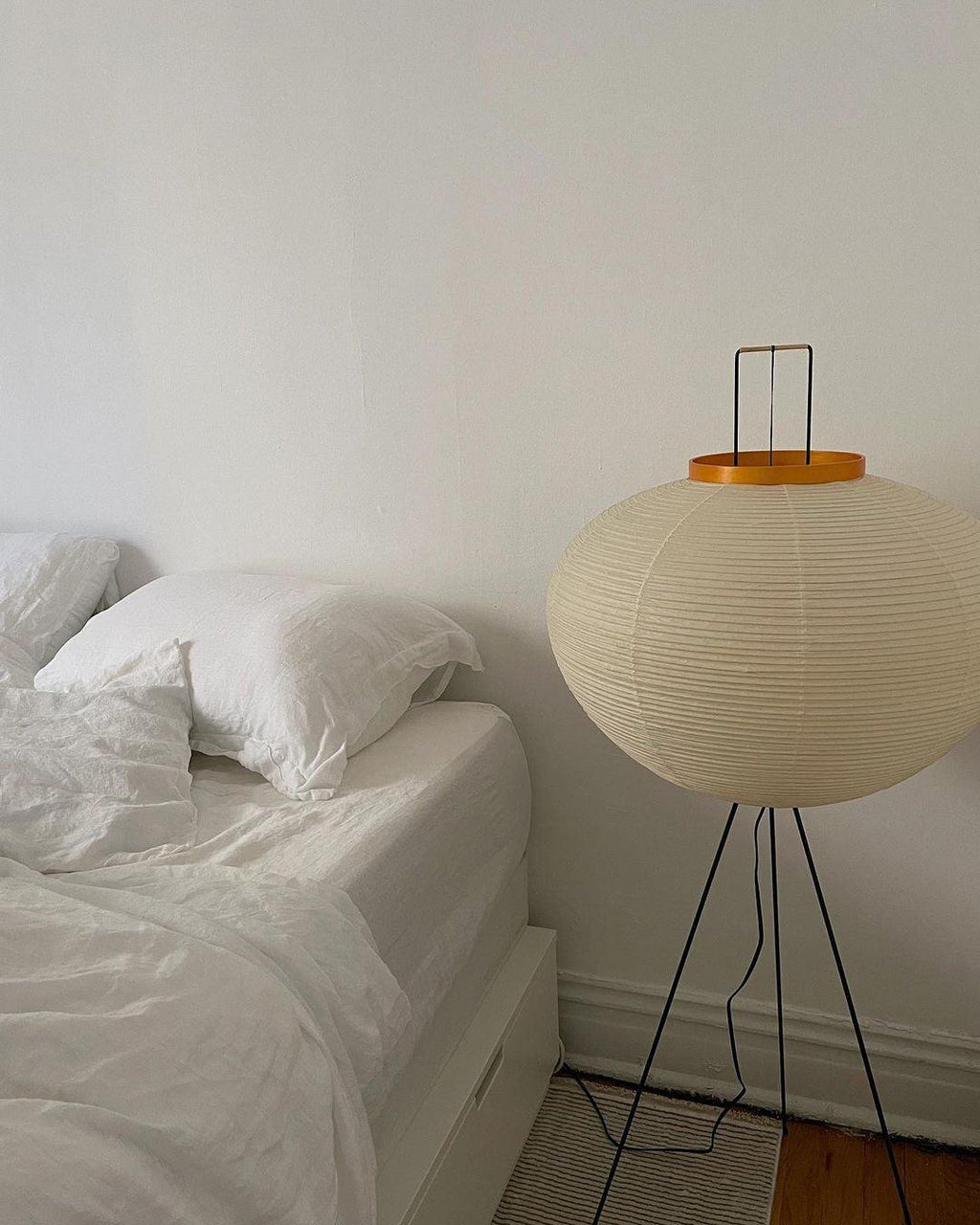 "Minimalist rice paper floor lamp with sleek metal frame and soft diffused light, perfect for creating a warm ambiance."