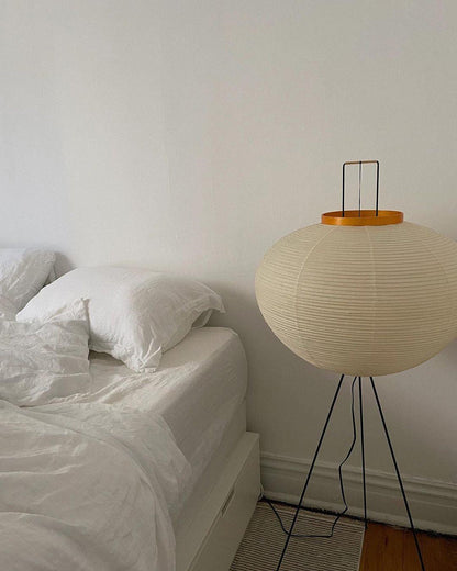 "Minimalist rice paper floor lamp with sleek metal frame and soft diffused light, perfect for creating a warm ambiance."
