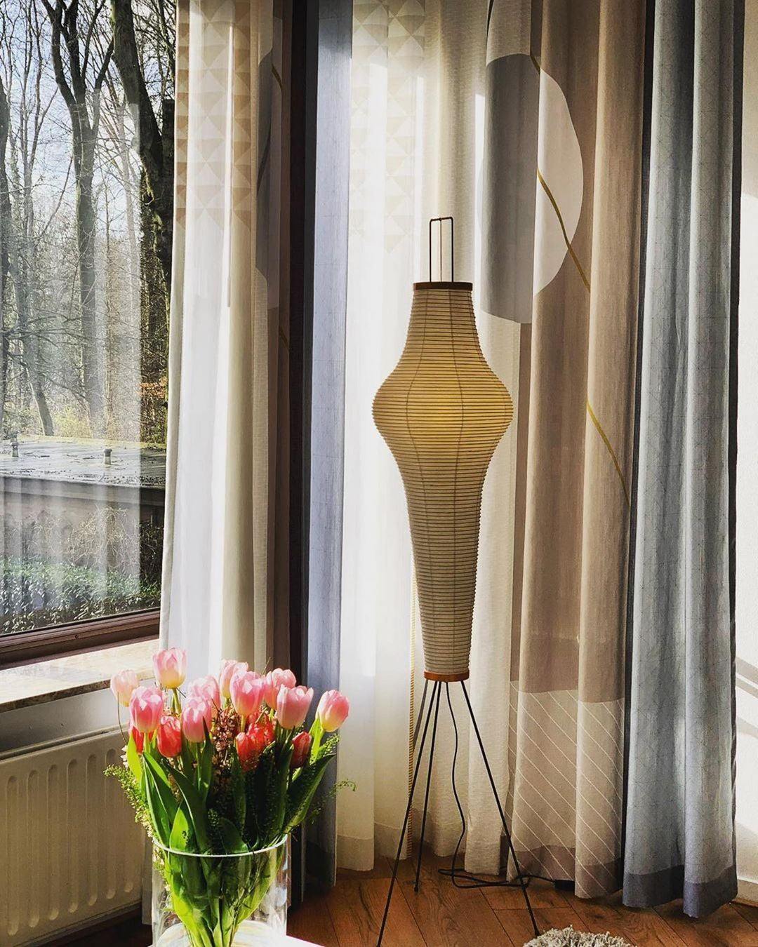 "Minimalist rice paper floor lamp with sleek metal frame and soft diffused light, perfect for creating a warm ambiance."