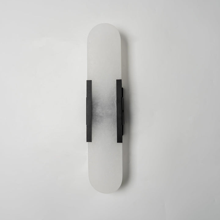 "Modern elongated alabaster wall lamp with metal and brass accents, emits warm glow, suitable for chic interior decor."