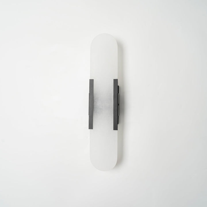 "Modern elongated alabaster wall lamp with metal and brass accents, emits warm glow, suitable for chic interior decor."