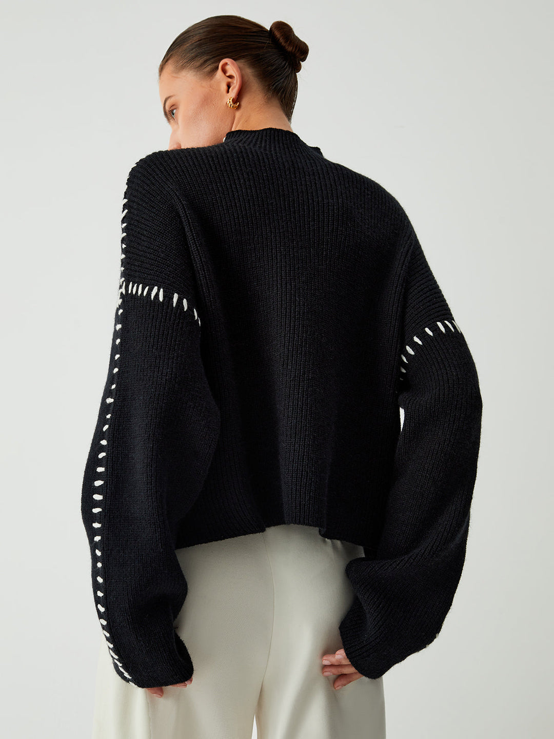 Women's oversized mock neck sweater styled casually, a modern layering piece for chilly days.