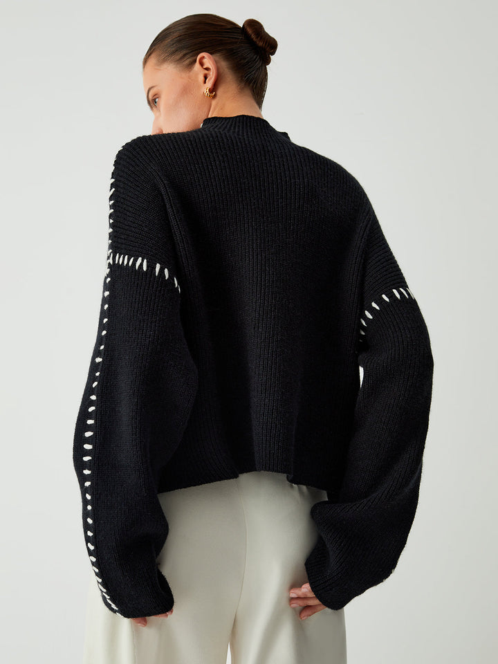 Women's oversized mock neck sweater styled casually, a modern layering piece for chilly days.