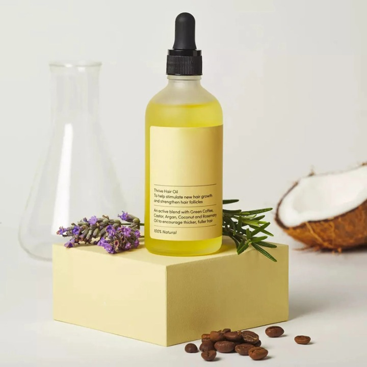 Natural Hair Growth Oil bottle, rich amber color, promises thicker hair with its 100% natural plant-based formulation.