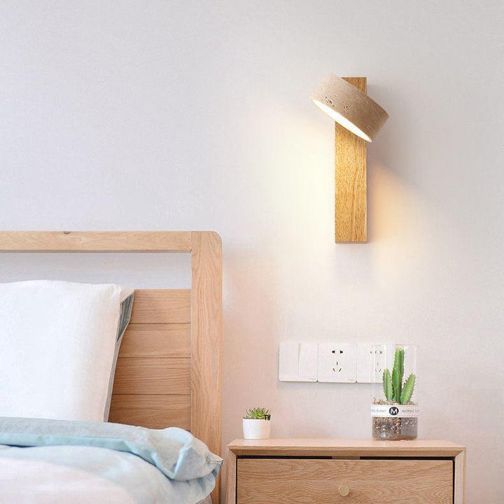 "Off-white travertine wall lamp with LED light, minimalist design, wood accents, ideal for ambient bedroom lighting."