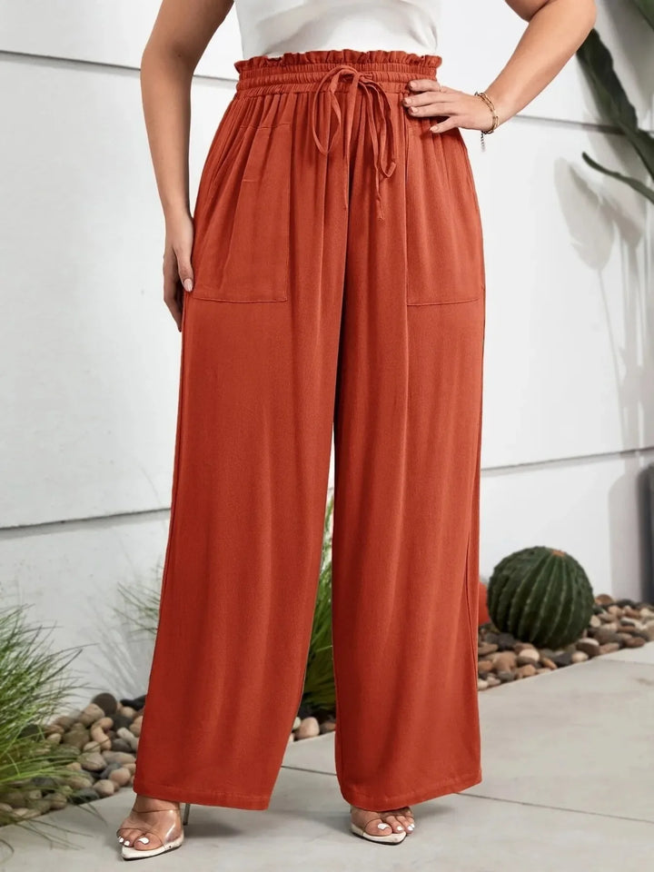 Curvy women's high waist wide leg pants with drawstring, offering a relaxed and flowy fit for vacation.