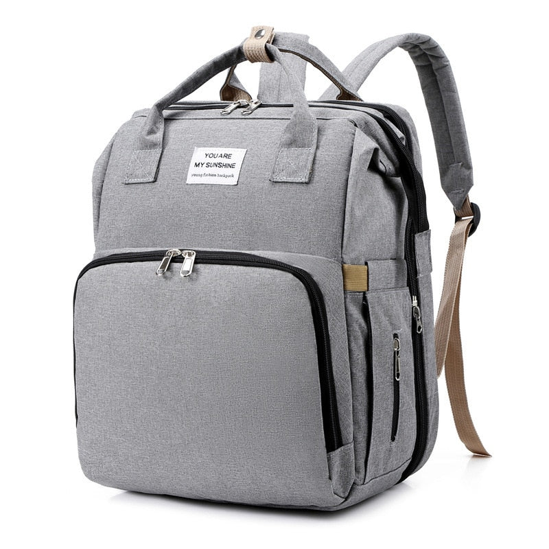 Stylish travel backpack opens into a comfy portable baby bed and changing station.