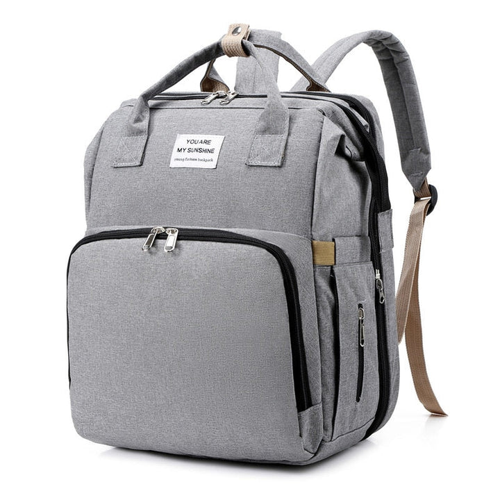 Stylish travel backpack opens into a comfy portable baby bed and changing station.