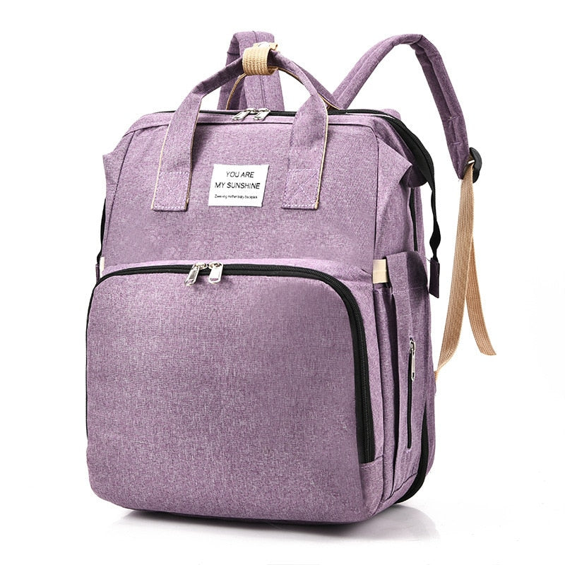 Parent's waterproof nappy bag transforms into a safe, portable baby bed for travel.