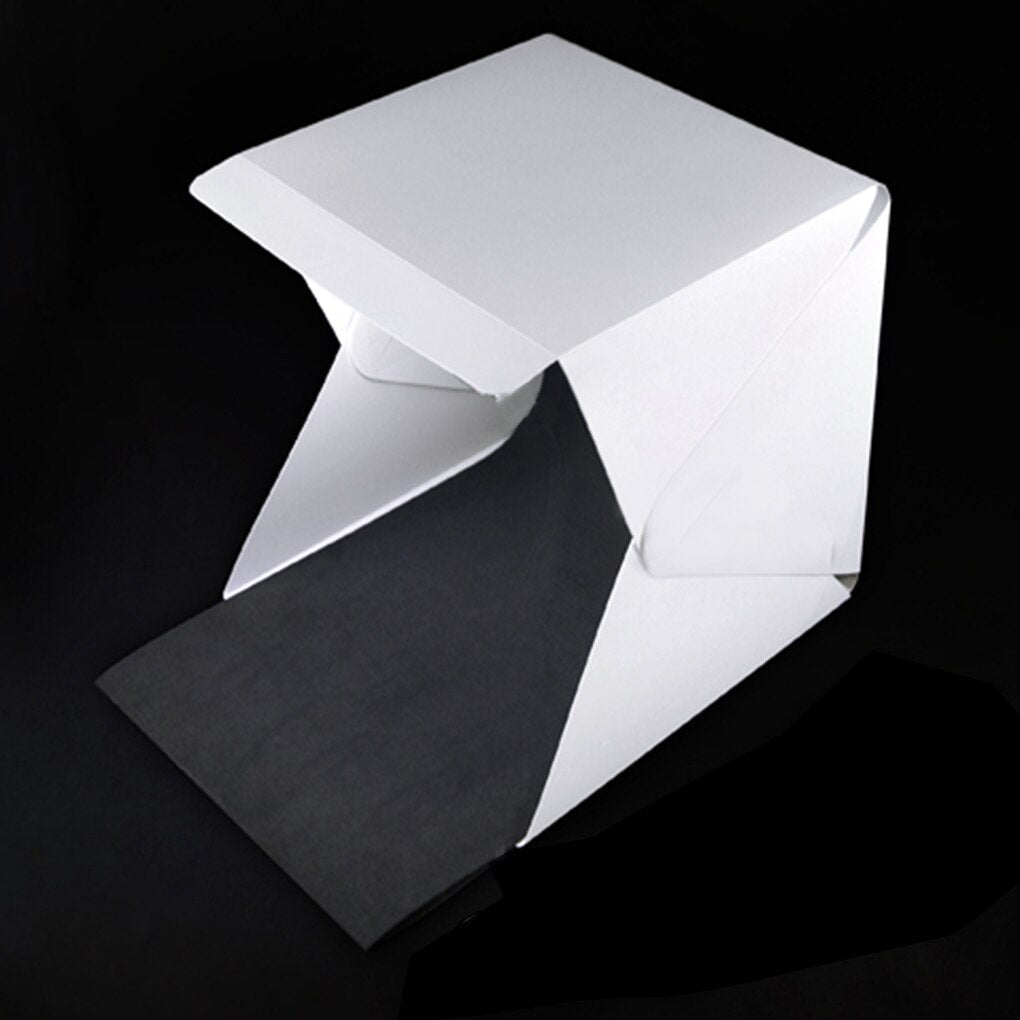 Mini photography light tent with adjustable LED lights & multiple backdrops. Easy setup for product shots.