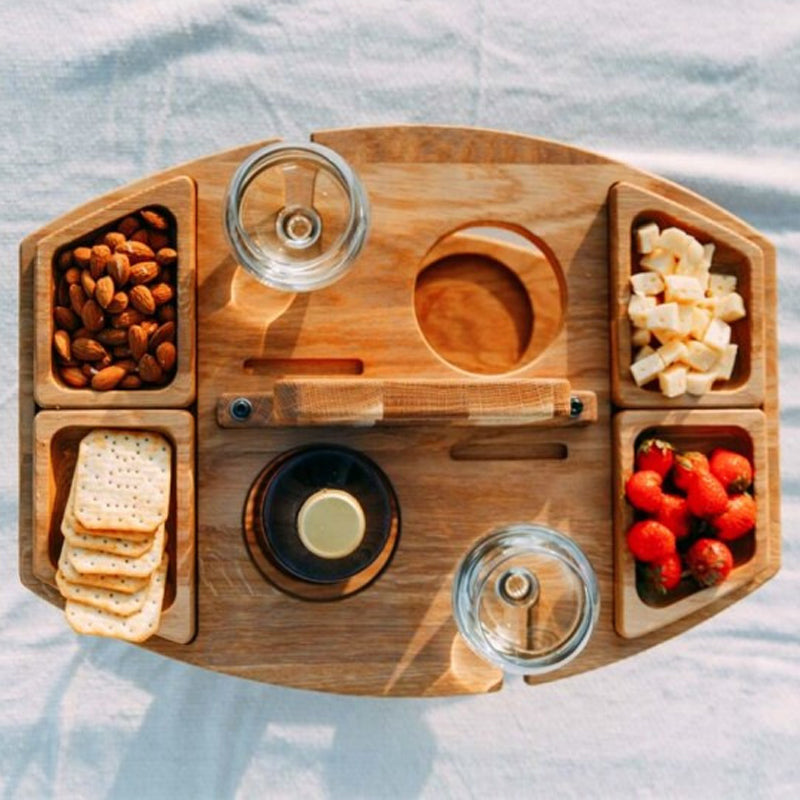 Wooden picnic table with wine glass slots. Foldable, portable design for outdoor dining & beach fun.