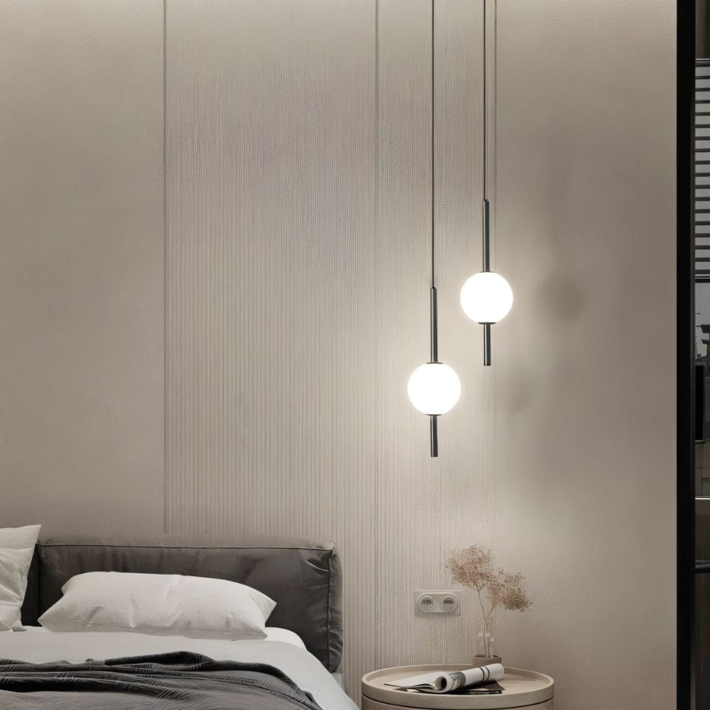 "Sleek glass ball Nordic pendant light with metal frame, LED bulb; available in black or brass, perfect for modern decor."
