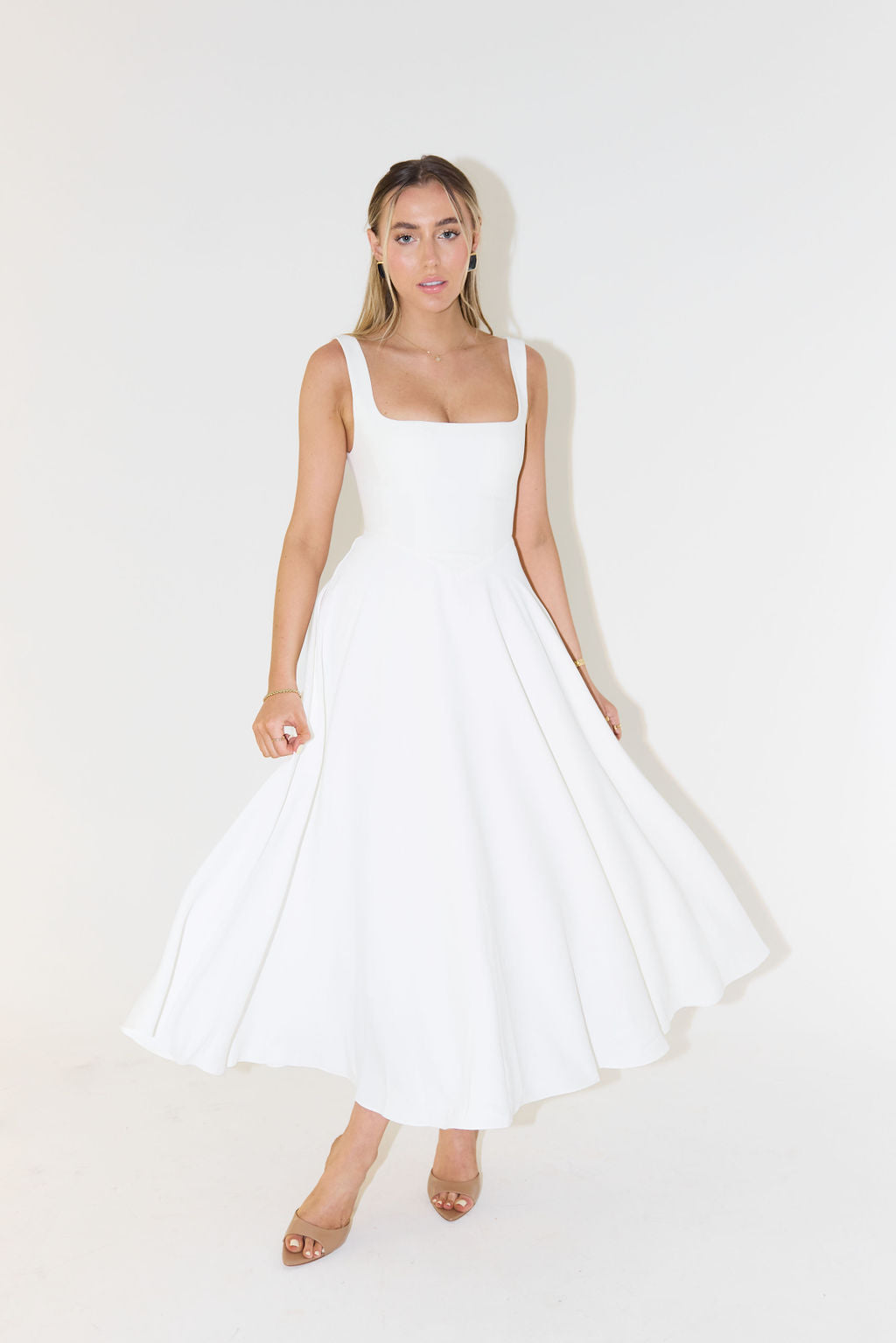 "Sleeveless satin midi dress with square neckline, fitted bodice; elegant women's fashion for special occasions."