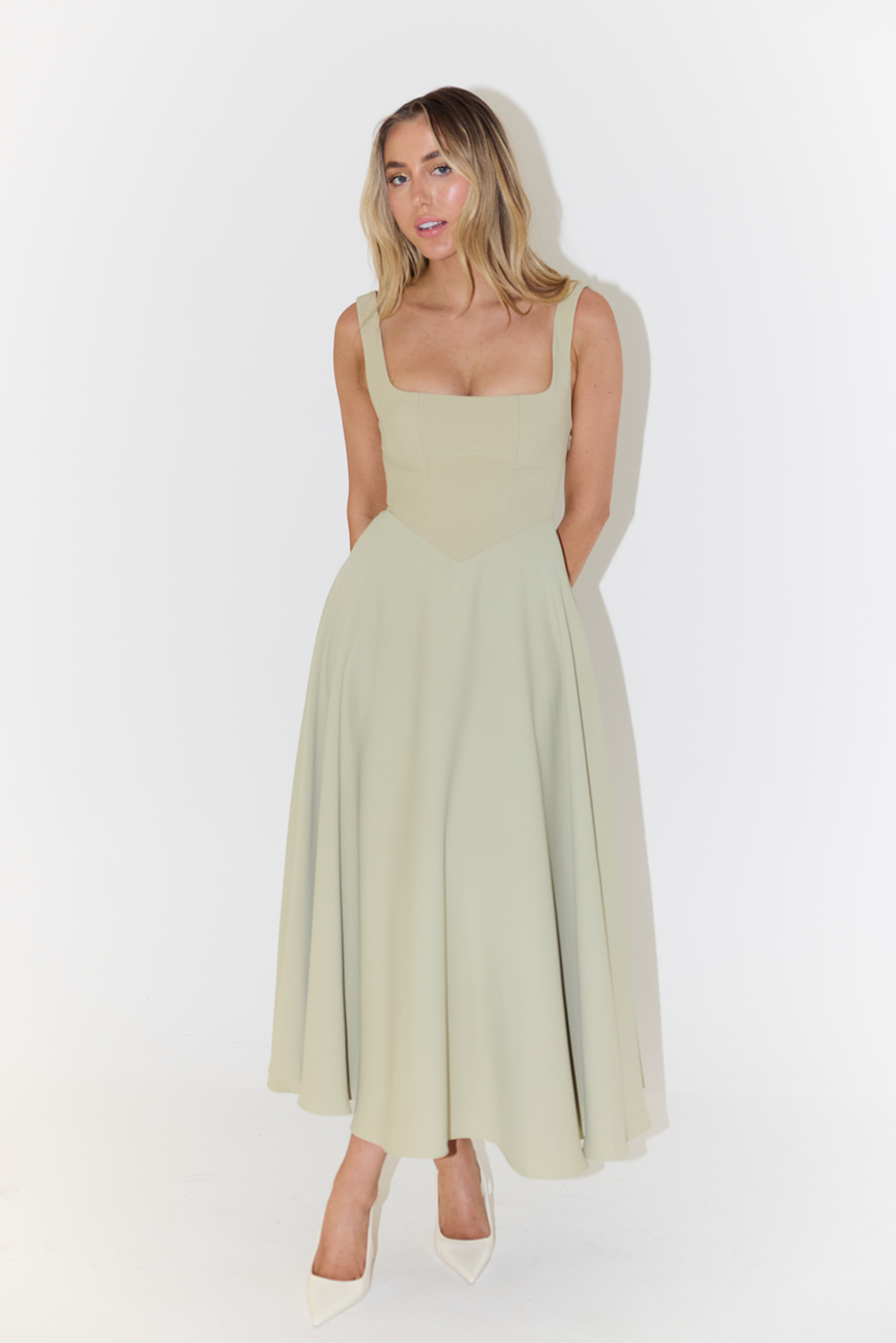 "Sleeveless satin midi dress with square neckline, fitted bodice; elegant women's fashion for special occasions."