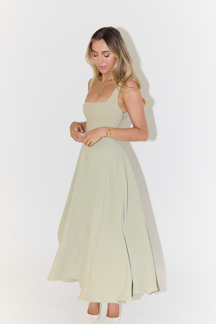 "Sleeveless satin midi dress with square neckline, fitted bodice; elegant women's fashion for special occasions."
