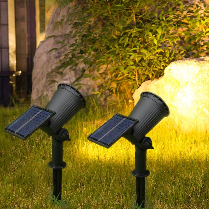 "Solar-powered LED garden spotlight with 9 color options, illuminating a pathway; eco-friendly outdoor lighting solution."
