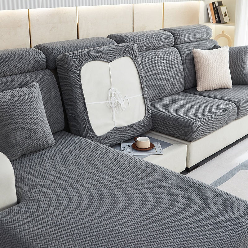 Stretchable sectional sofa cover in vibrant tangerine, snug fit, durable fabric, ideal for home decor and furniture protectio