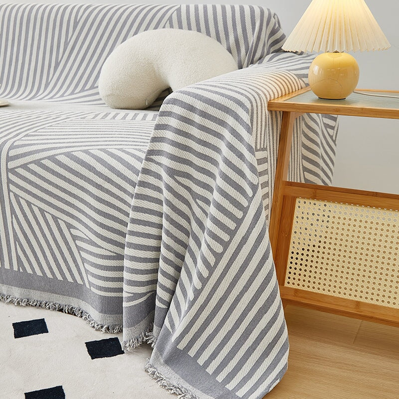 "Striped sofa throw cover, durable stretchable fabric, minimalist pattern, elevates living space, protects against spills."