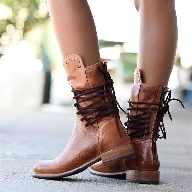 Women's black studded mid-calf boots featuring detailed lace-up design and a comfortable low heel.